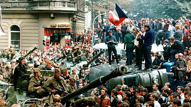 Im August 1968 umringen Demonstranten in Prag sowjetische Panzer und stehen mit einer Fahne der Tschechoslowakei auf einem umgekippten ...