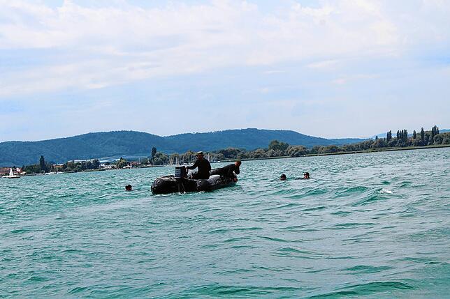 Jetzt sind gleich vier Soldaten im Wasser und müssen von einem Boot aufgenommen werden.