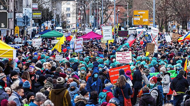 Teilnehmer einer Demonstration gegen die Corona-Maßnahmen stehen in der Freiburger Innenstadt.