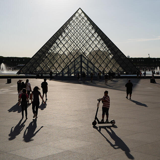 Touristen vor der Pyramide des Louvre in Paris.