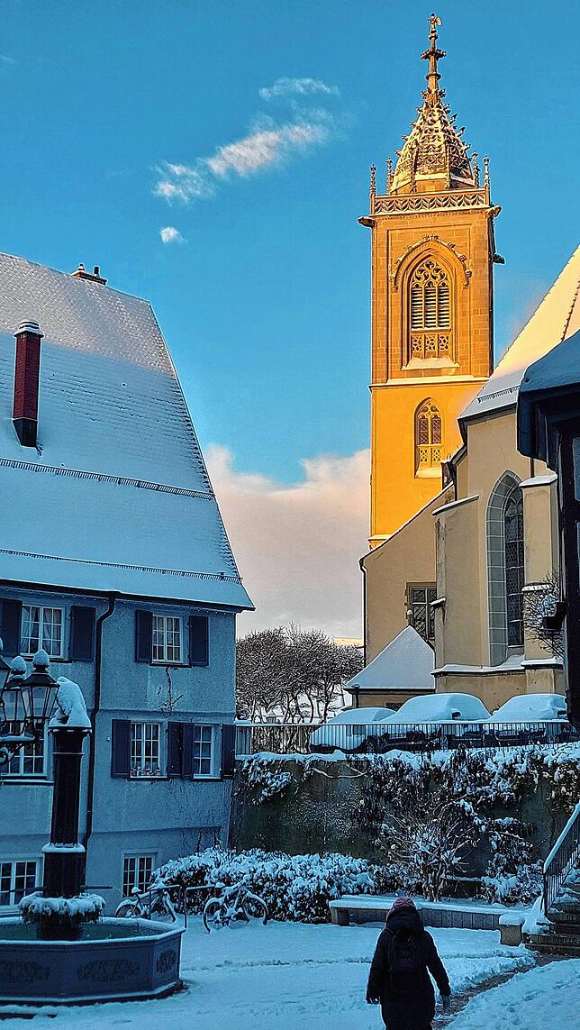 Die Sonne strahlt die Stadtkirche St.Jakobus an, vorne ist der Hechtbrunnen zu sehen.