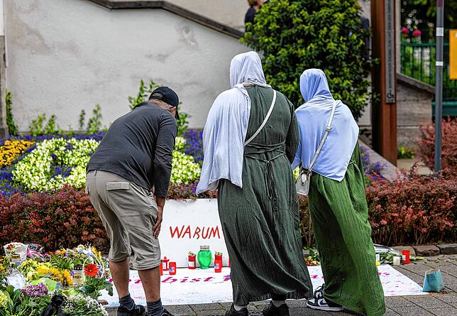Nach der Messerattacke auf dem Solinger Stadtfest legen Menschen in der Nähe des Tatortes Blumen und Kerzen zum Gedenken der Opfer nieder.