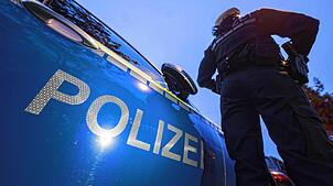 Eine Polizistin steht neben einem Polizeifahrzeug. (Symbolbild)