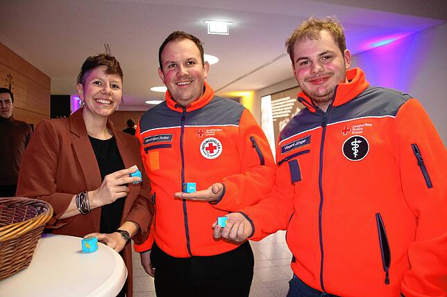 Corinna Eckert verteilt am Eingang Pralinen an die Besucher, hier an Maximilian Reiter und Vincent Jünger vom DRK.