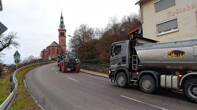 Mehrere Dutzend Traktoren, Lastwagen und Zugmaschinen mit Warnblinkern und Hupen auf der L151 in Laufenburg.