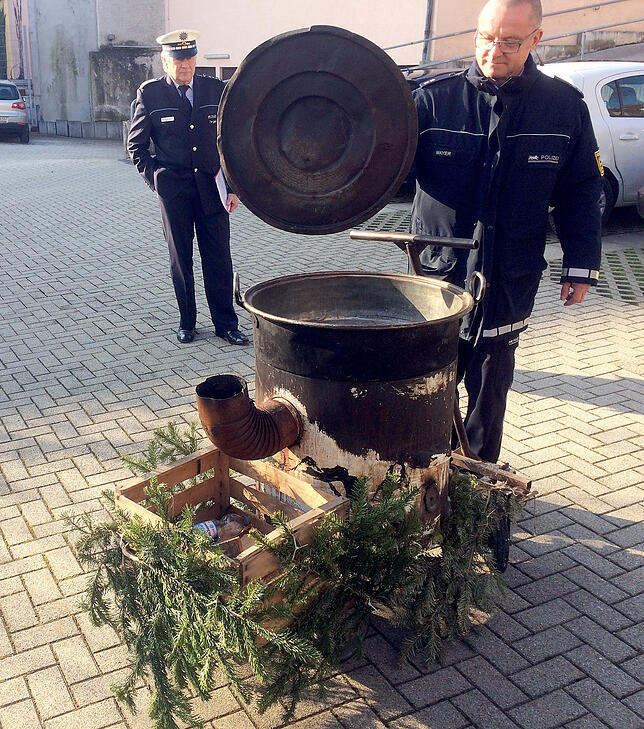 Polizisten stehen vor der Polizeiwache an einem Kessel, in dem sich  bei einem Fastnachtsumzug eine junge Frau mit heißem Wasser an den ...