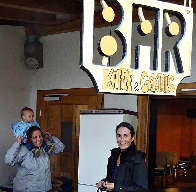 Der kleine Jan Roth sitzt vergnügt auf den Schultern von Birgitta Schäfer. Sybille Roth wird in wenigen Augenblicken den Thresen der Bar ...