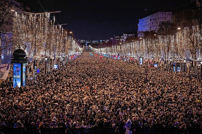 Feiernde sehen eine Ton- und Lichtshow, die auf den Arc de Triomphe projiziert wird, während sie das kommende Jahr auf den Champs ...