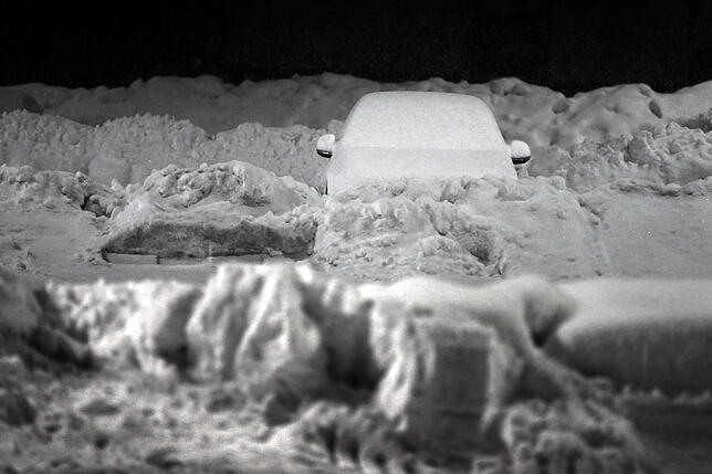Kaufbeuren: Ein schneebedecktes Auto steht auf dem Parkplatz eines Supermarktes.