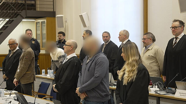 Die Angeklagten und ihre Anwälte stehen auf, als das Gericht den Saal in Koblenz betritt.