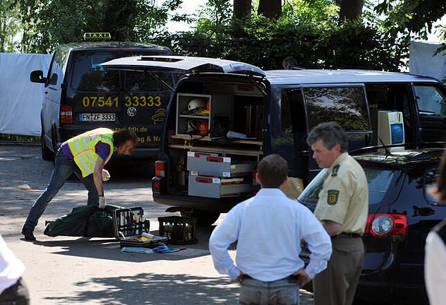 Ein Beamter der Kriminalpolizei steht am 09.06.2010 in Hagnau am Bodensee vor dem Wagen der ermordeten Taxifahrerin.