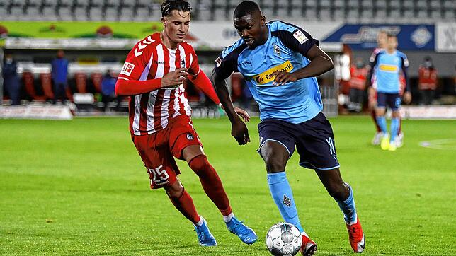 Mönchengladbachs Marcus Thuram und Freiburgs Robin Koch kämpfen um den Ball.