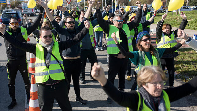 Demonstranten der &ldquo;Gelbwesten&bdquo; strecken mitten auf einer Straße in Marseille ihre Hände in die Luft und halten gelbe ...