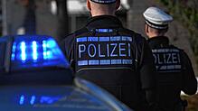Polizisten stehen bei ihrem Einsatzwagen (Symbolbild). Nach einer Großfahdnung am Hochrhein wird in Waldshut ein 23-Jähriger festgenommen.