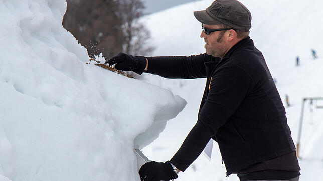 Ein Künstler arbeitet beim Schneeskulpturenfestival 2019 an einer Skulptur. 2020 muss das Festival wegen Schneemangel ausfallen.