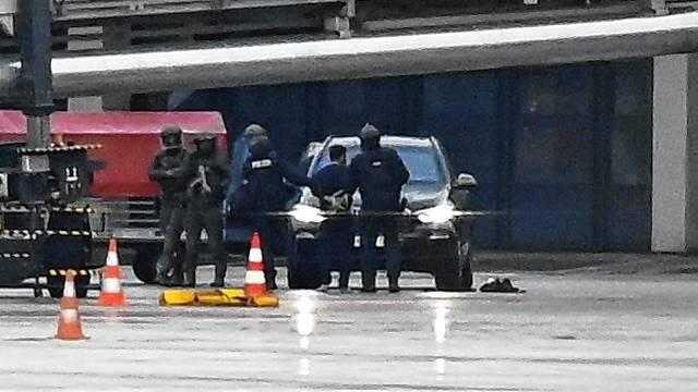 Ein Mann wird auf dem Flughafen von der Polizei weggeführt. Ein bewaffneter Mann hattee auf dem Airport seine vierjährige Tochter in ...