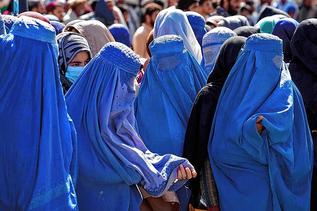 Frauen warten in Kabul auf Lebensmittelrationen, die von einer humanitären Hilfsorganisation verteilt werden. Seit der Machtergreifung ...