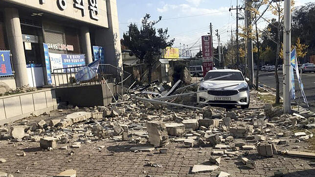 Trümmer einer zusammengestürzten Mauer liegen am 15.11.2017 in Pohang (Südkorea) vor einem Gebäude. Ein Erdbeben der Stärke 5,4 hat den ...
