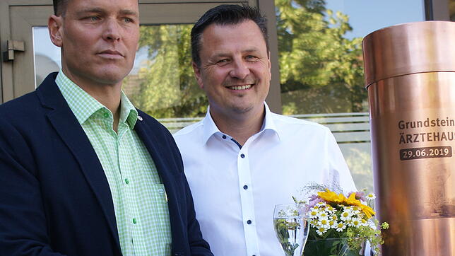 Markus Brands von Trenova Immobilien (links) und Bürgermeister Adrian Schmidle präsentierten die Kupferhülse, die die Zeitdokumente im ...