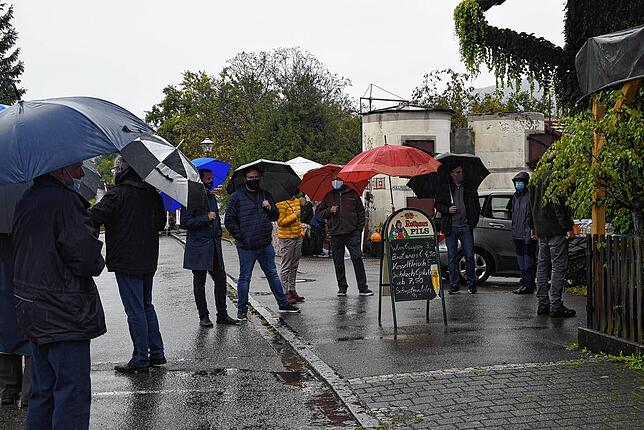 Bei strömendem Regen warten Ehrengäste und Besucher auf die Eröffnung des Naturparkmarkts.