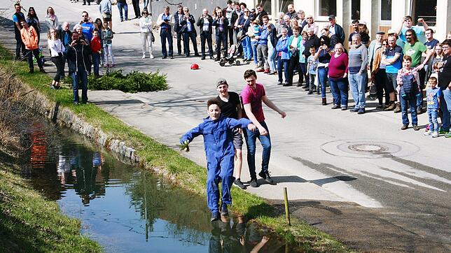 Der Bär Kai Baumann springt ins kalte Wasser des aufgestauten Baches.