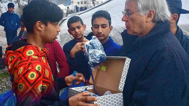 Claus Kittsteiner übergibt Hilfsgüter an einen Flüchtling auf Lesbos.