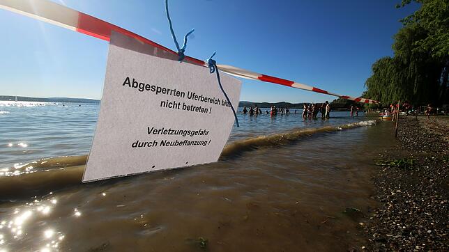 Absperrband flattert am Strandbad Unteruhldingen. Dennoch können Schwimmer ins Wasser. Nur nicht überall.