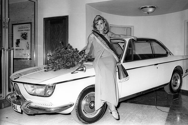 Laziv an einen BMW gelehnt, posiert Liliana Atterer, Miss Germany von 1968 für die Kameras.