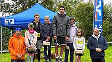 Die strahlenden Sieger des 2300-Meter-Laufs der Schüler und Jugendlichen, umrahmt von Vertretern der Hauptsponsoren der Veranstaltung. ...