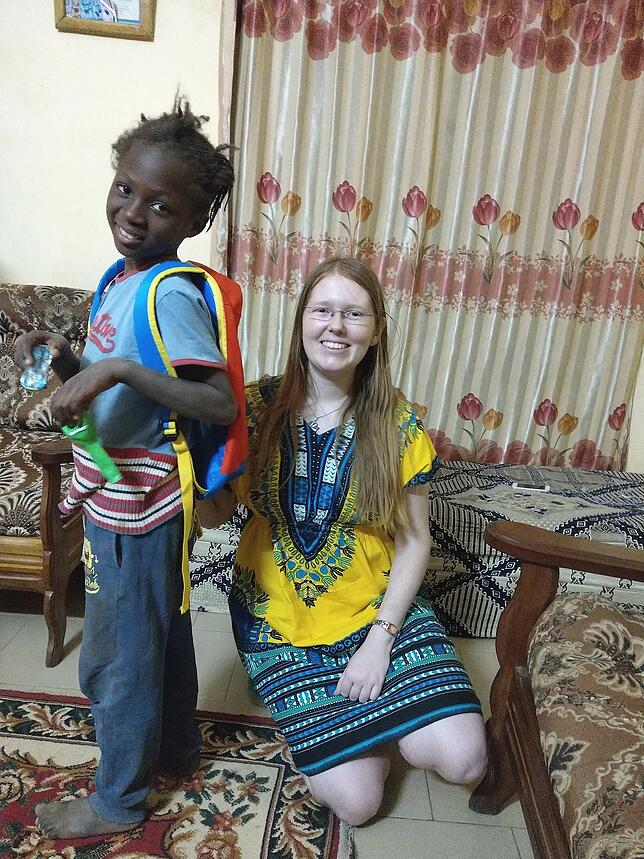 Ein afrikanisches Kind freut sich über einen gespendeten Rucksack und Spielzeug.