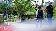 Zwei Polizisten stehen vor einer Brücke am Stadtrand von Filderstadt. In Filderstadt wurde ein Koffer mit einer Leiche darin unter einer ...