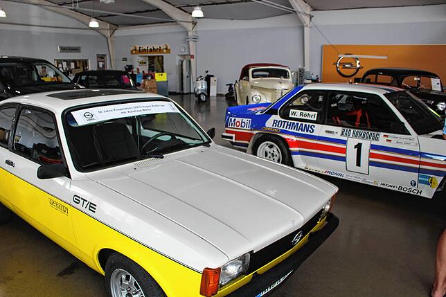 Ein Blick in die Ausstellung im Autohaus Martin. Vorne zwei Rennwagen, hinten mehrere Oldtimer.