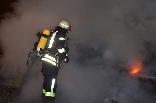 Nur mit Atemmaske können sich die Feuerwehrleute durch den dicken Rauch wagen.