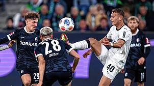Philipp Treu (SC Freiburg) (l-r), Matthias Ginter (SC Freiburg) und Jan Urbich (Bor. Mönchengladbach) kämpfen um den Ball.