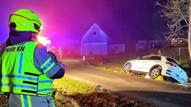 Einsatzkräfte der Feuerwehr haben das Unfallauto mit Rampen gesichert, damit es nicht weiter abrutscht.