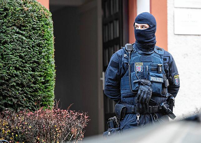 Bei der Razzia gegen sogenannte &bdquo;Reichsbürger&ldquo; sichert ein Polizist ein durchsuchtes Objekt in Frankfurt.