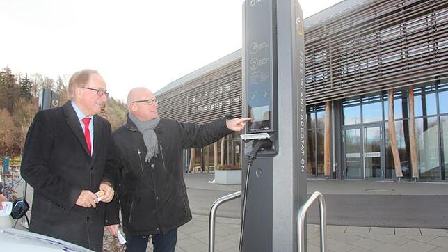 EnBW-Kommunalberater Rico Goede erläutert Bürgermeister Edgar Lamm die Funktion der neuen E-Ladesäule vor dem Welterbesaal.