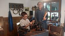 Werner Schmid übergibt seinem jüngsten Enkel Felix das Amt des Bürstenmachers im Erzählmuseum in Ibach.