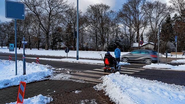 Ein Fußgänger und ein Rollstuhlfahrer überqueren den Zebrastreifen in der Vöhrenbacher Straße – im Hintergrund fährt ein Auto ...